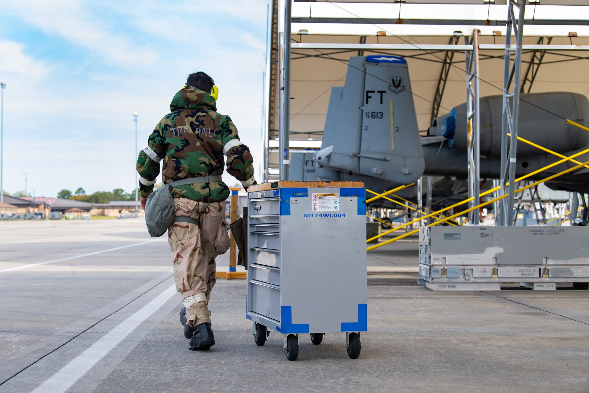 Photo of an Airman pushing a maintenance cart