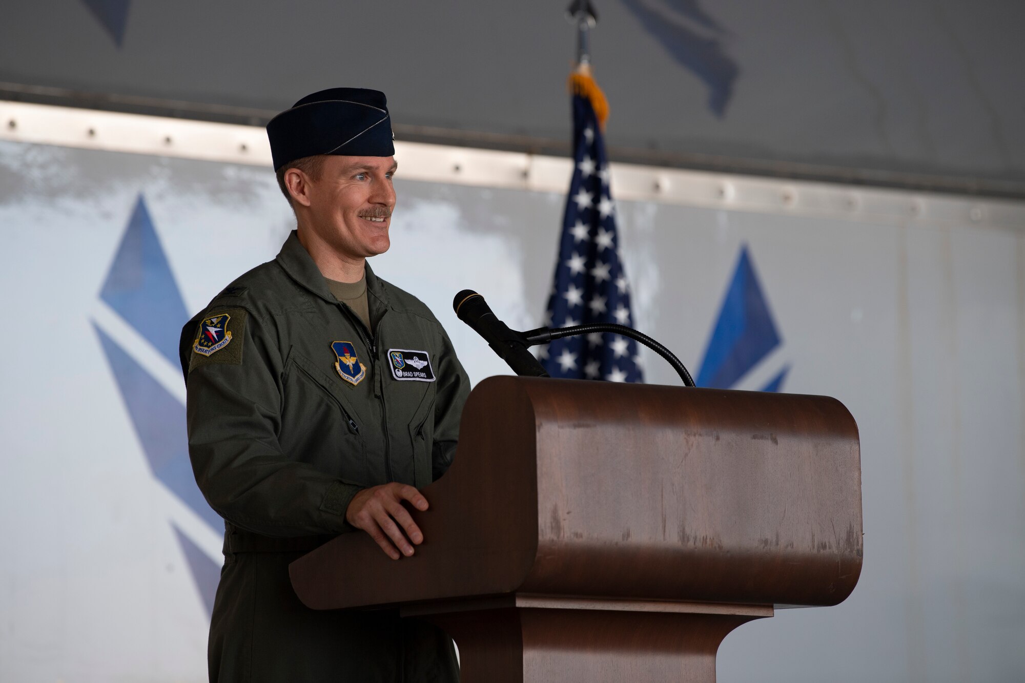 A photo of a service members standing at a podium.