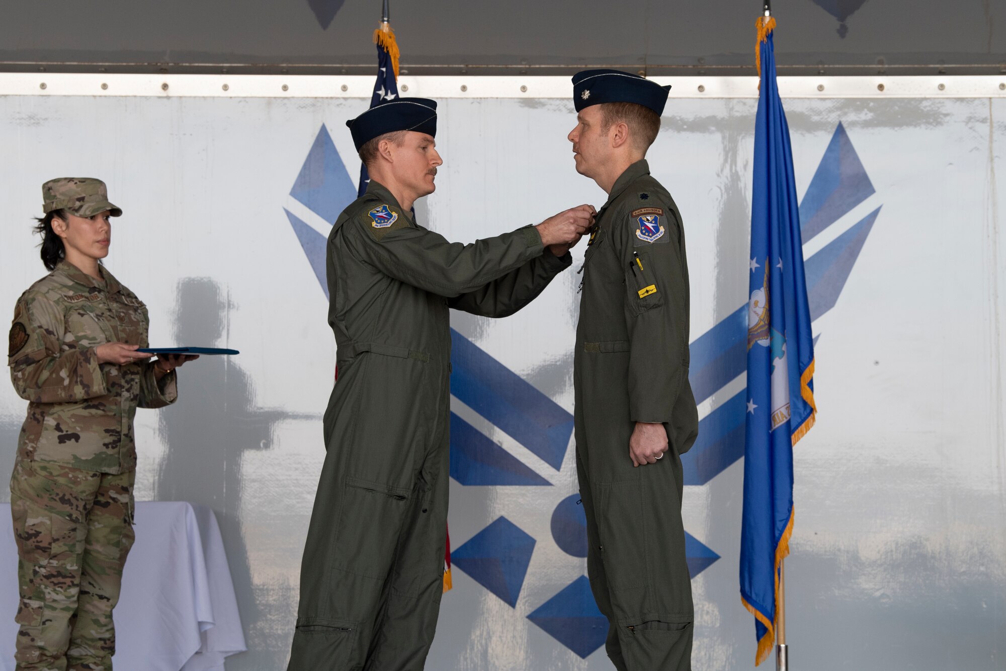 A photo of a service member pinning a medal on to another service members uniform.