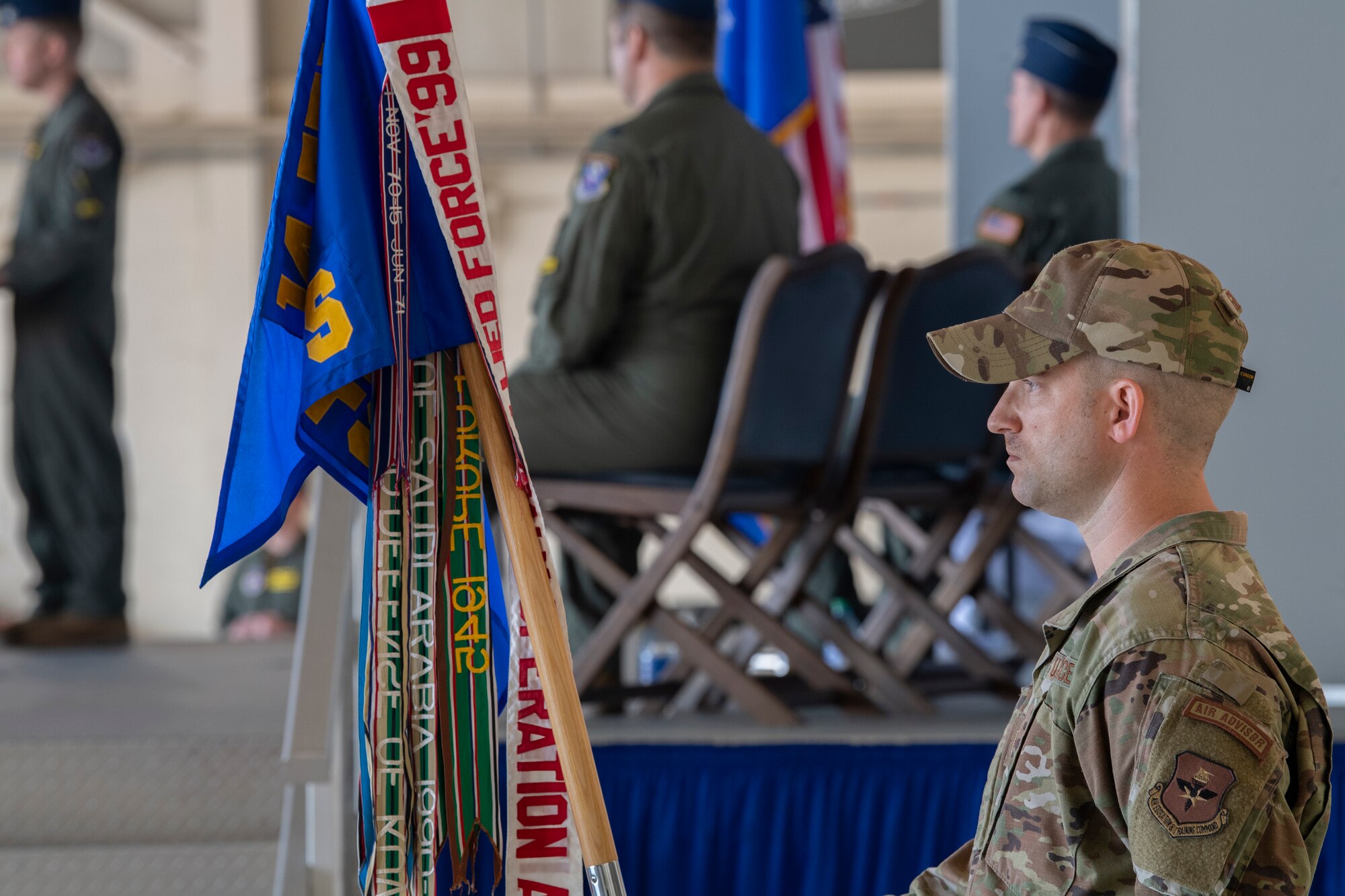 A photo of standing at parade rest holding a guidon.