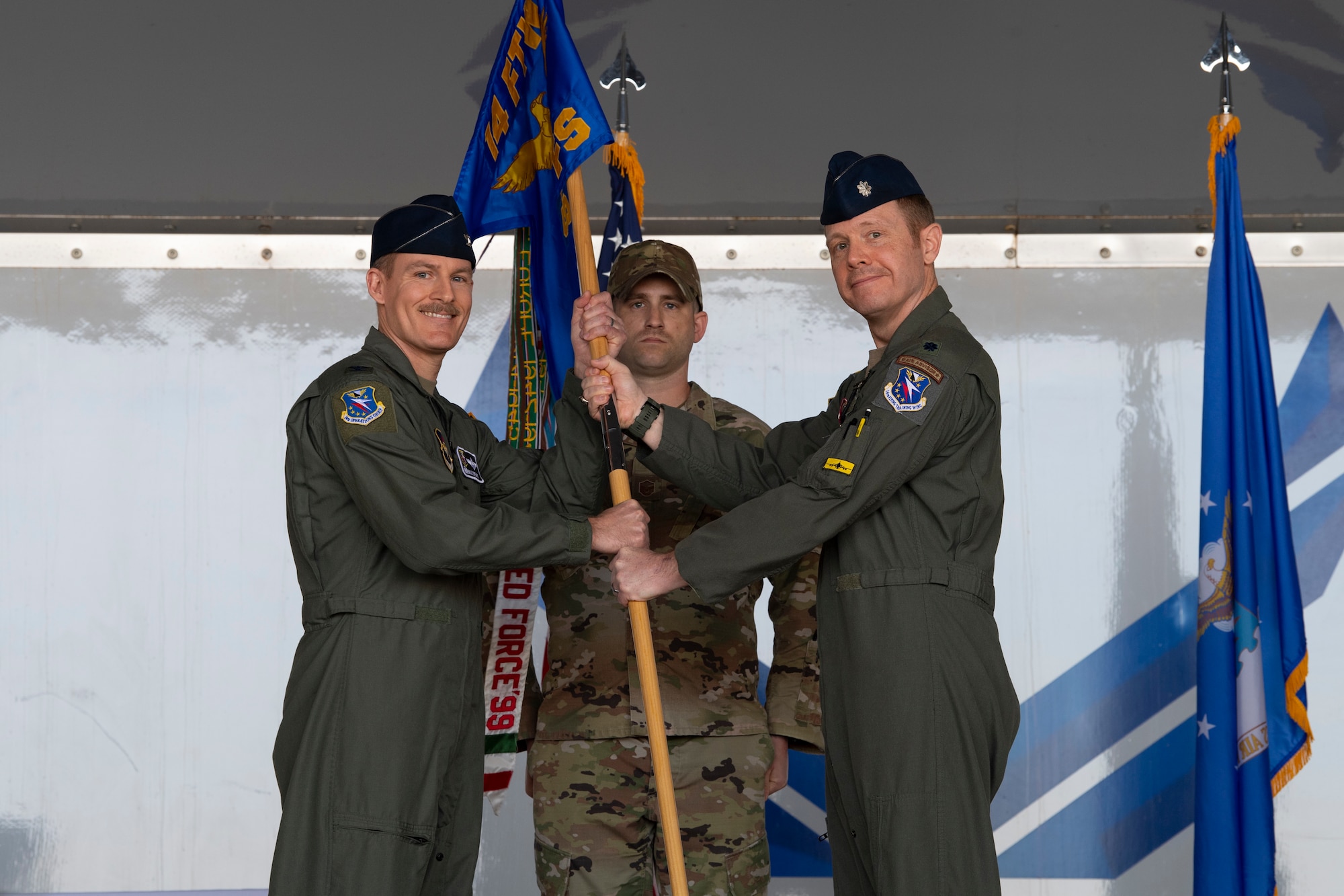 A photo of two service members holding on to a guidon.