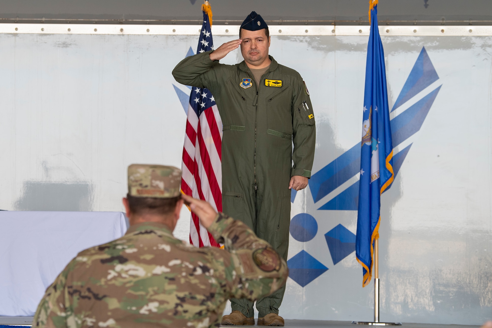 A photo of two service members saluting each other.