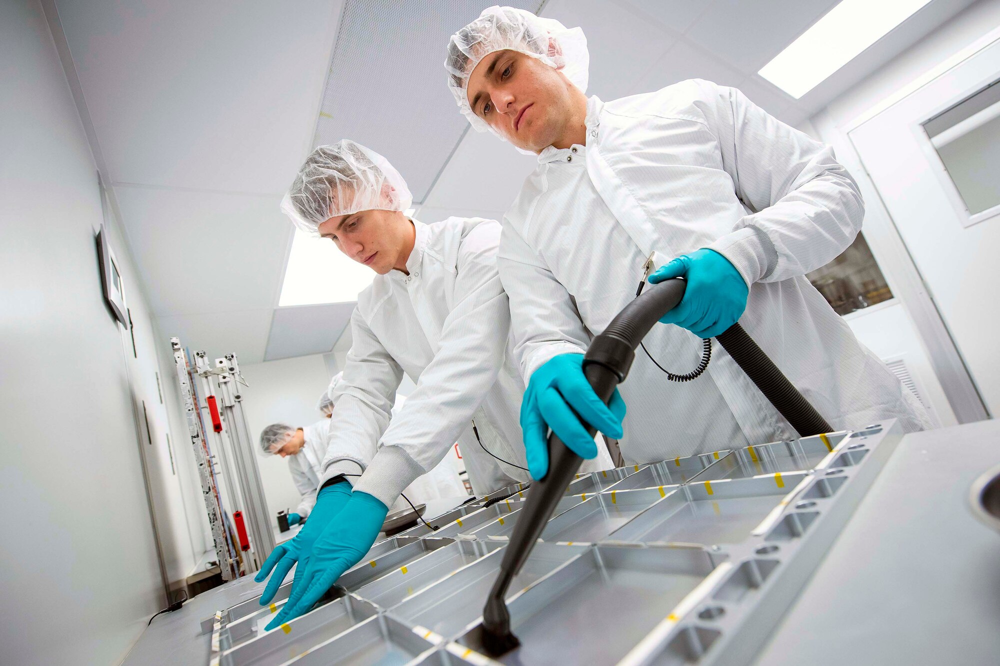 Air Force Academy cadets Wade Lawrie and Dominic Flack clean a FalconSAT X structural panel