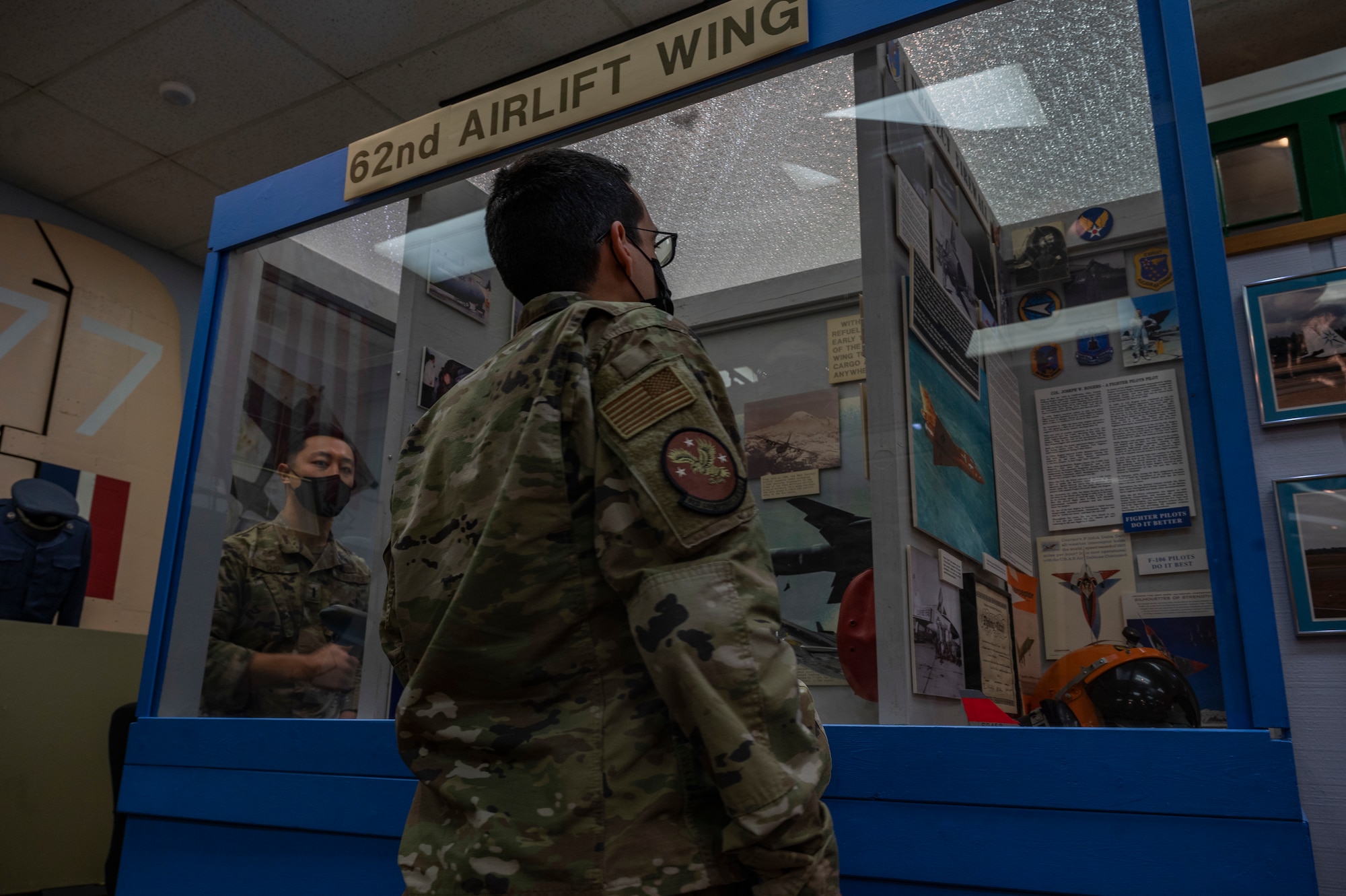 Airmen assigned to the 62nd Airlift Wing  look at a display case in the McChord Air Museum at Joint Base Lewis-McChord, Washington, Feb. 22, 2022. After being closed for almost two years due to the COVID-19 pandemic, the Air Museum reopened its doors to the public. (U.S. Air Force photo by Airman 1st Class Charles Casner)
