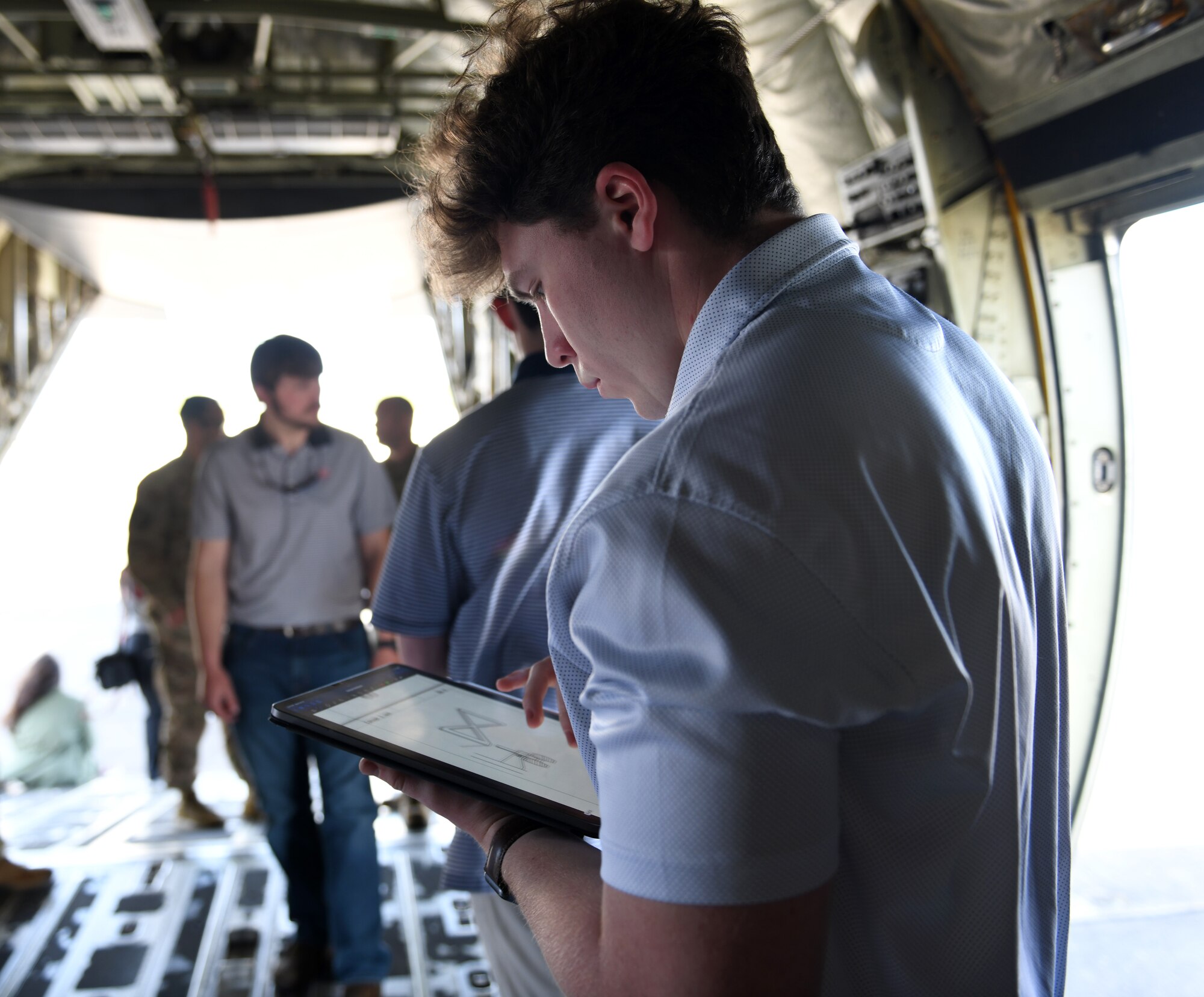 An Auburn University engineering student studies aircraft parts for research Feb 16, 2022 at Maxwell Air Force Base, Al. Air University’s Innovation Center and MGMWERX partnered with the 187th Fighter Wing and the 908th airlift wing to provide Auburn University students with a C-130 loading demo and C-17 static. (U.S. Air Force photo by Senior Airman Rhonda Smith)