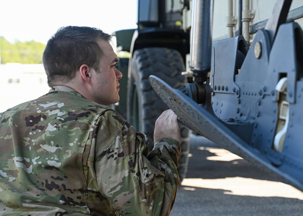 A loadmaster from the 41st Airlift Squadron directs cargo into a C-130J Super Hercules