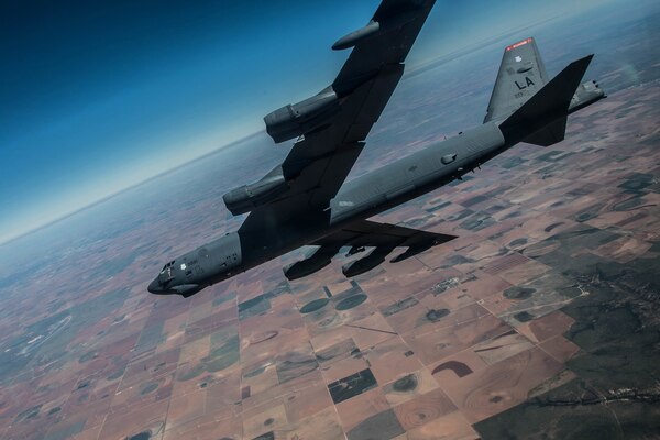 An aircraft flies over farmland.