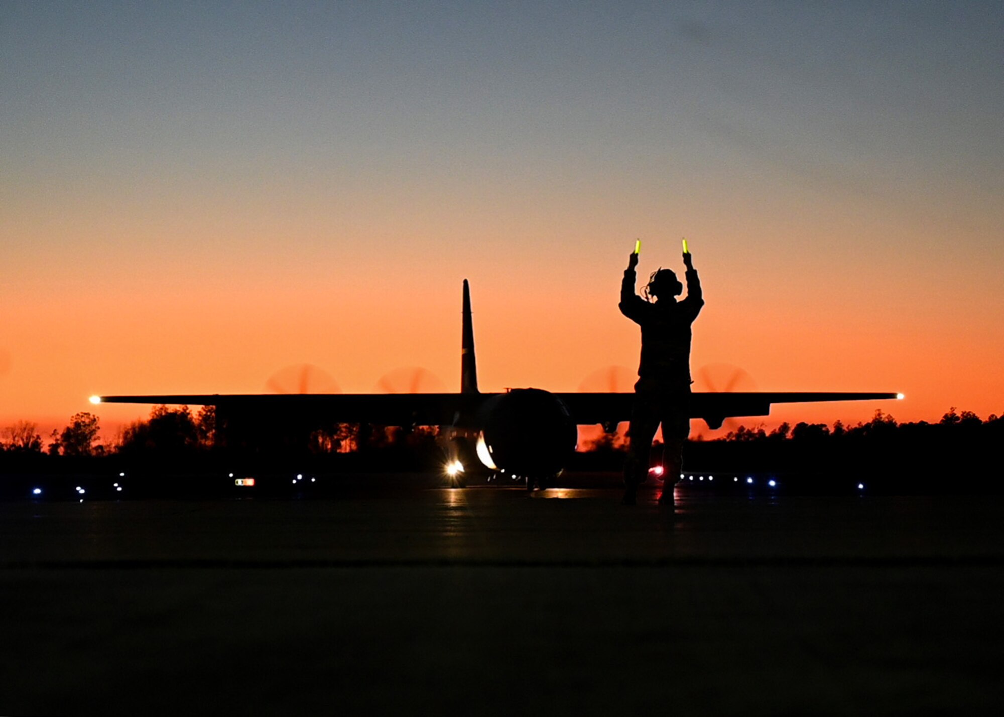 Senior Airman Darius Haithcox, 19th Aircraft Maintenance Squadron flying crew chief, directs a C-130J Super Hercules to its parking spot