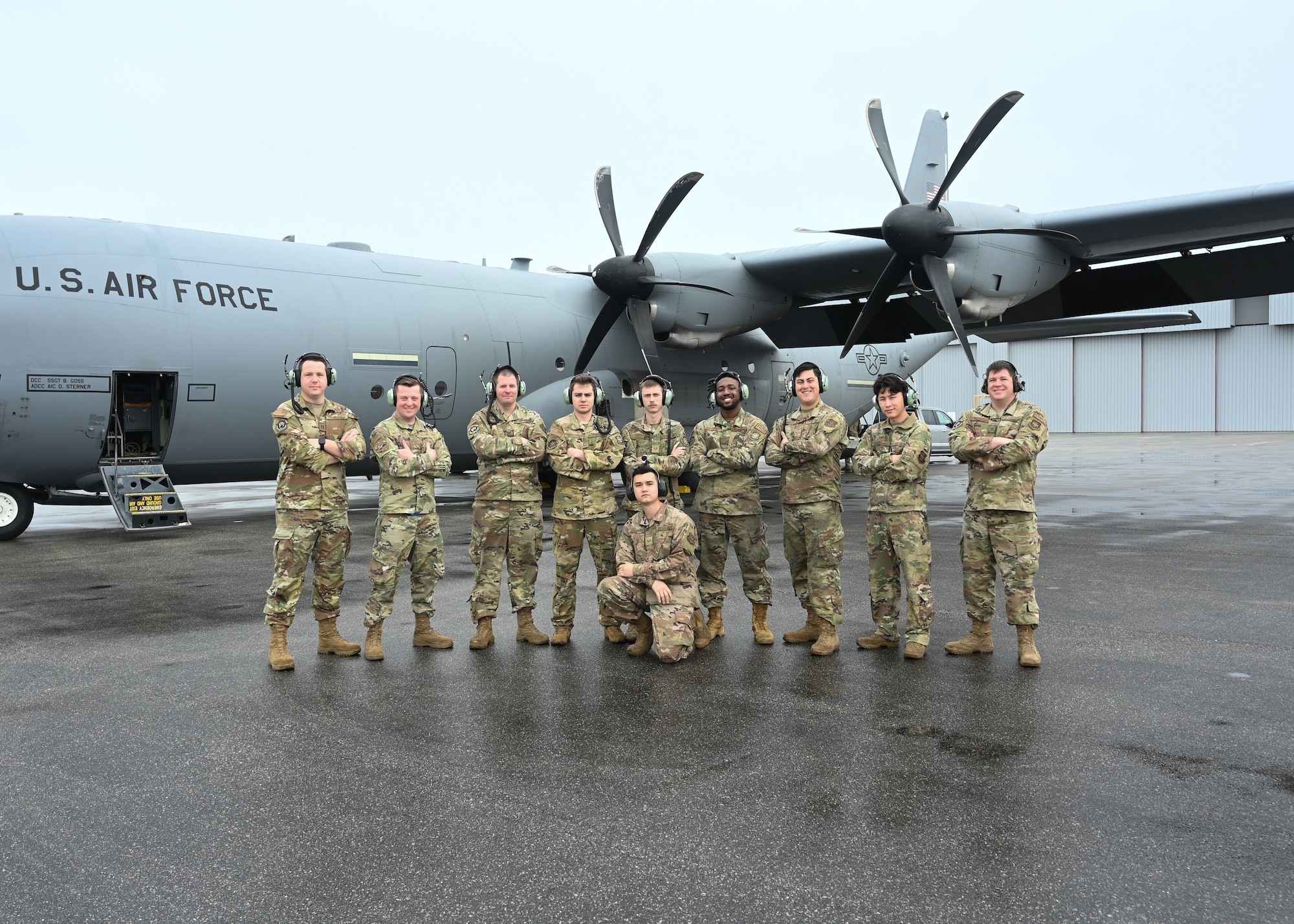 Airmen assigned to the 19th Aircraft Maintenance Squadron pose for a photo in front of a C-130J Super Hercules