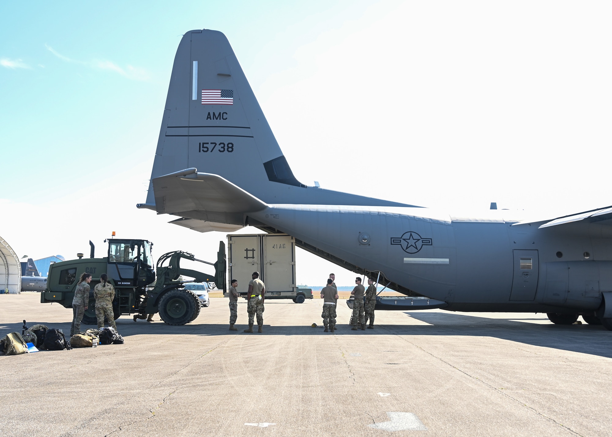 A loadmaster from the 41st Airlift Squadron directs cargo into a C-130J Super Hercules