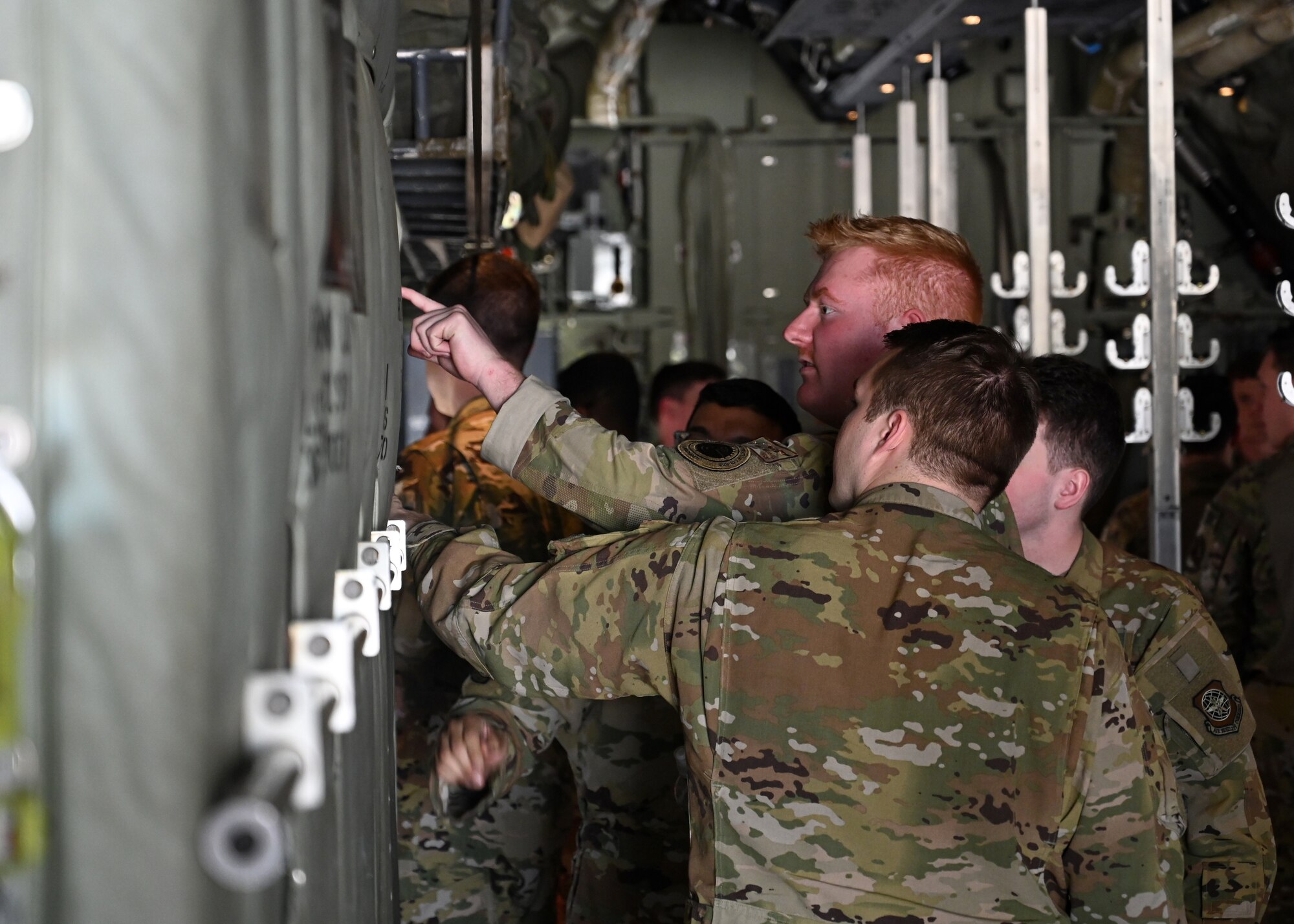 Loadmasters and pilots from the 41st Airlift Squadron work together to set up chairs in a C-130J Super Hercules