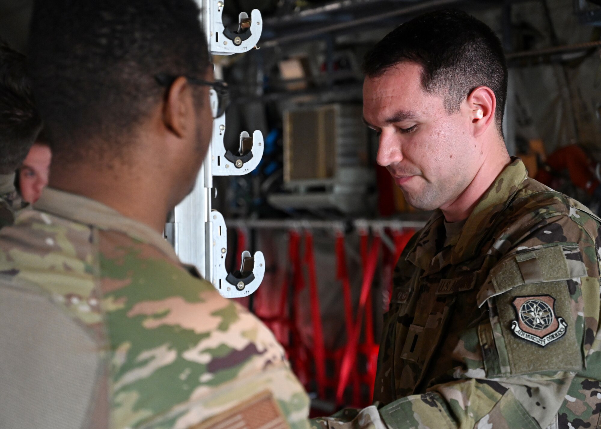 A pilot from the 41st Airlift Squadron installs a chair support beam in a C-130J Super Hercules