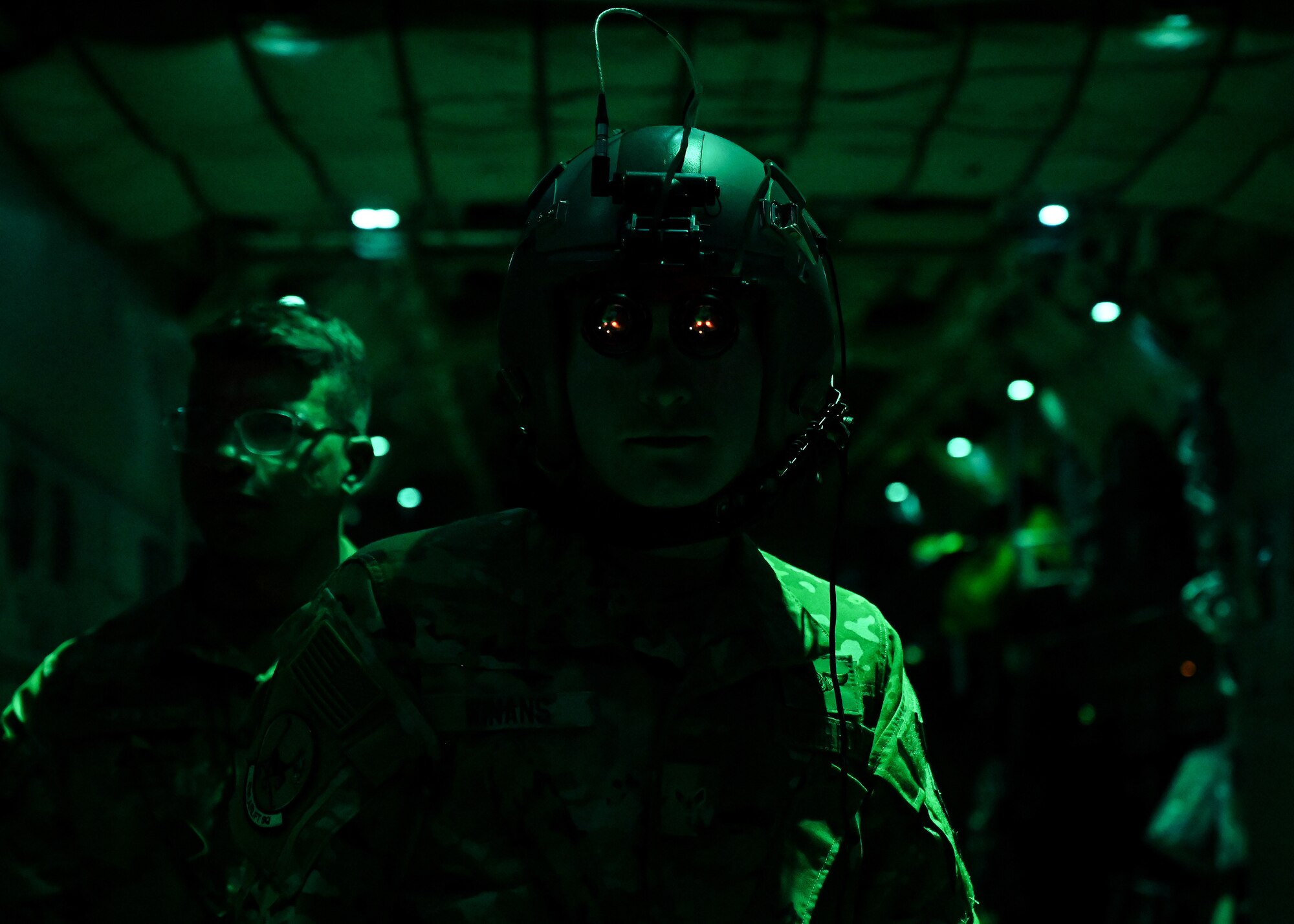 A loadmaster from the 41st Airlift Squadron uses night vision goggles