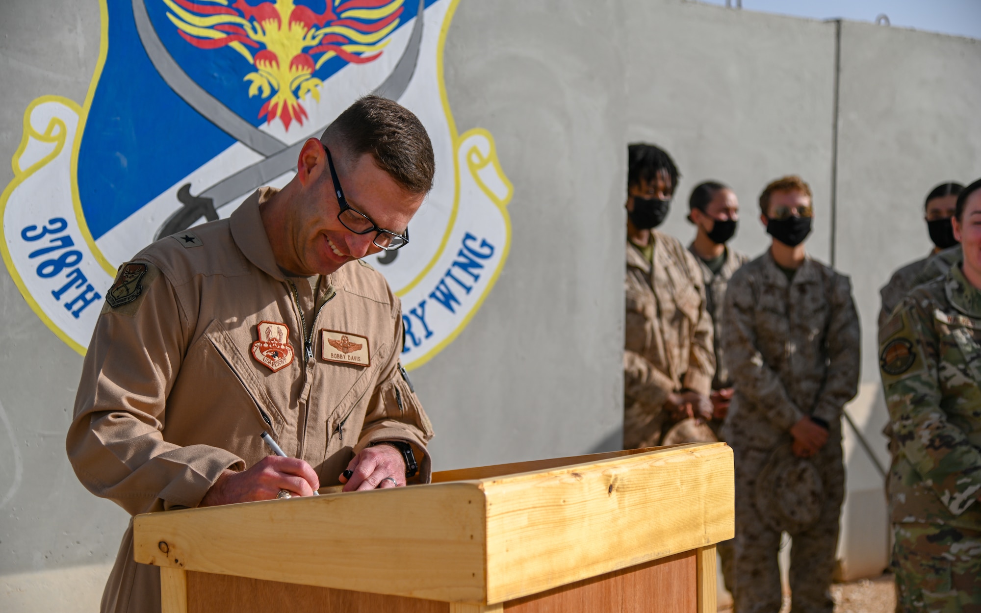 U.S. Air Force Brig. Gen. Robert Davis, 378th Air Expeditionary Wing commander, signs the official Prince Sultan Air Base Women’s History Month Proclamation alongside members of the installation Women’s Empowerment Group at Prince Sultan Air Base, Kingdom of Saudi Arabia, Mar. 1, 2022. The Women’s Empowerment Group is composed of women from sister services across the installation. (U.S. Air Force photo by Staff Sgt. Christina Graves)