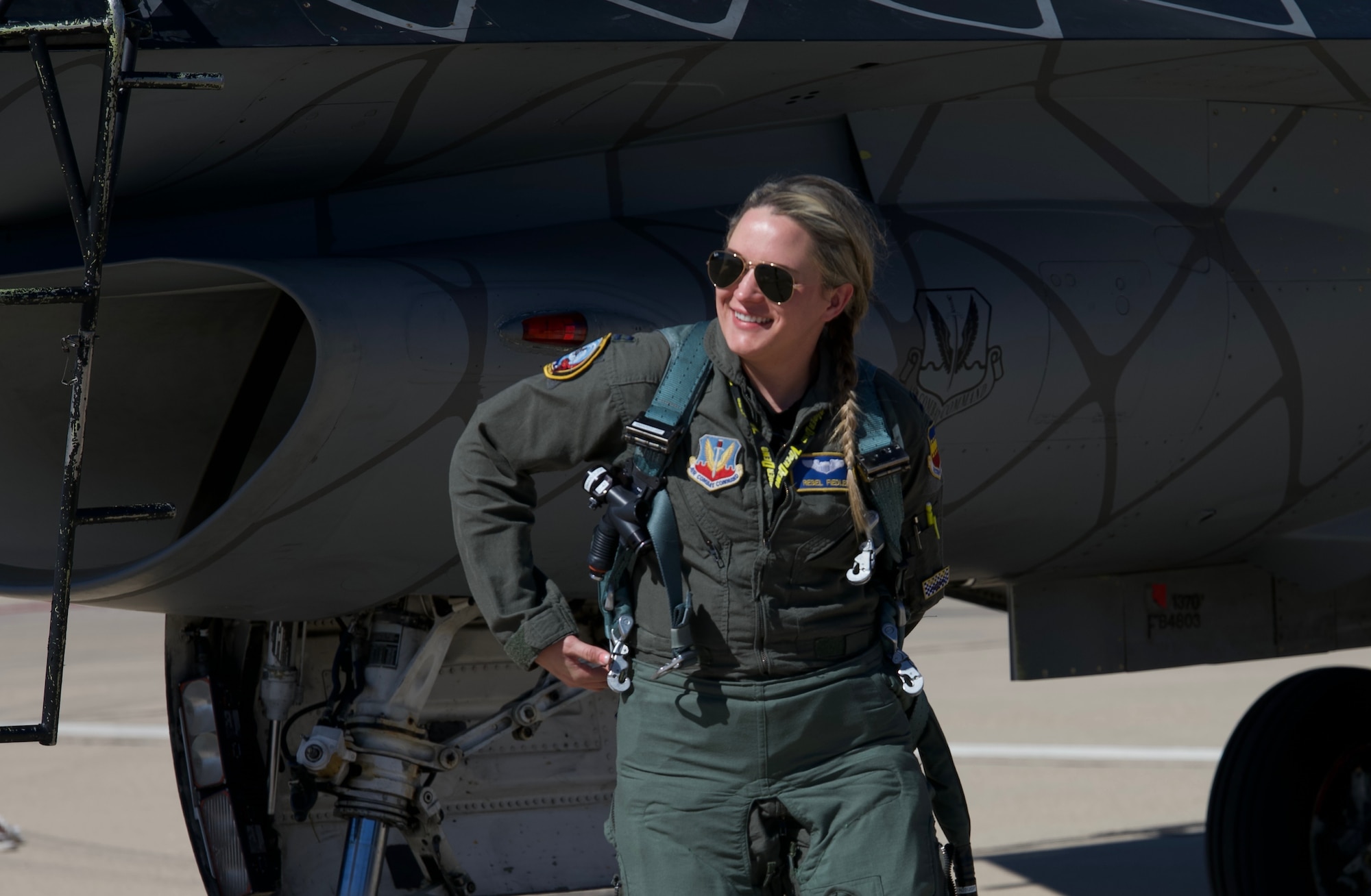 A picture of Capt Fiedler walking away from her F-16 at Davis Monthan Air Force Base.