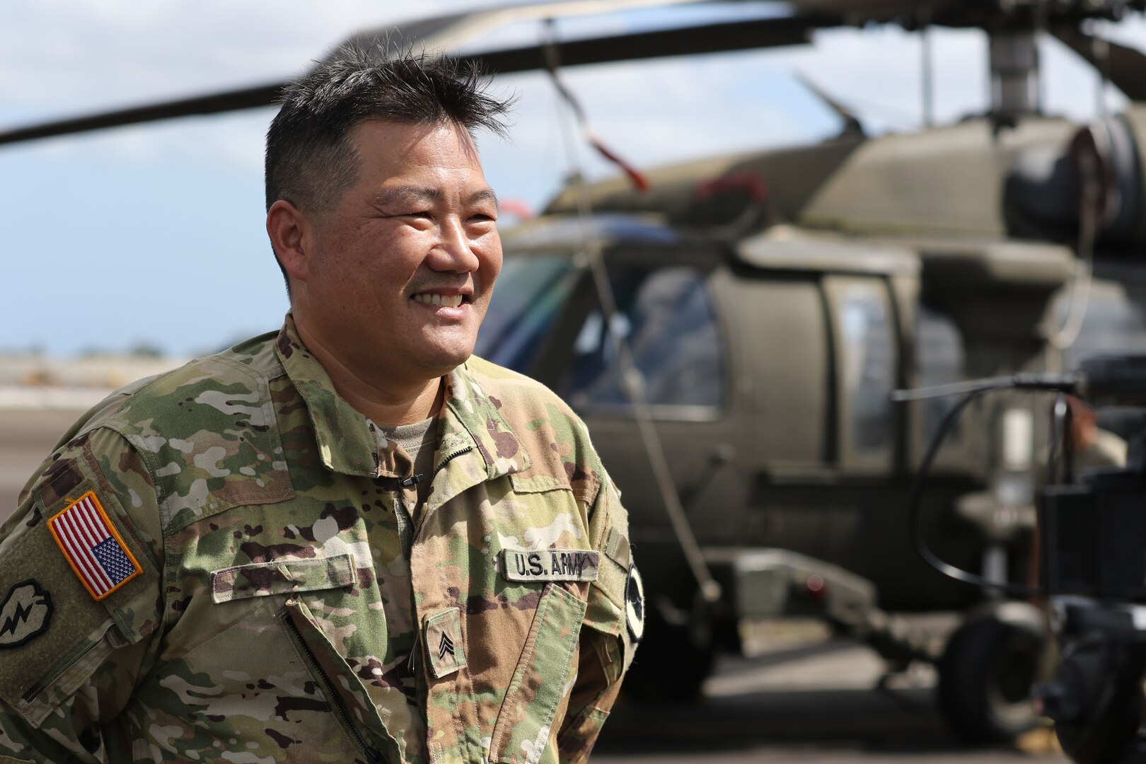 Smiling service member next to helicopter