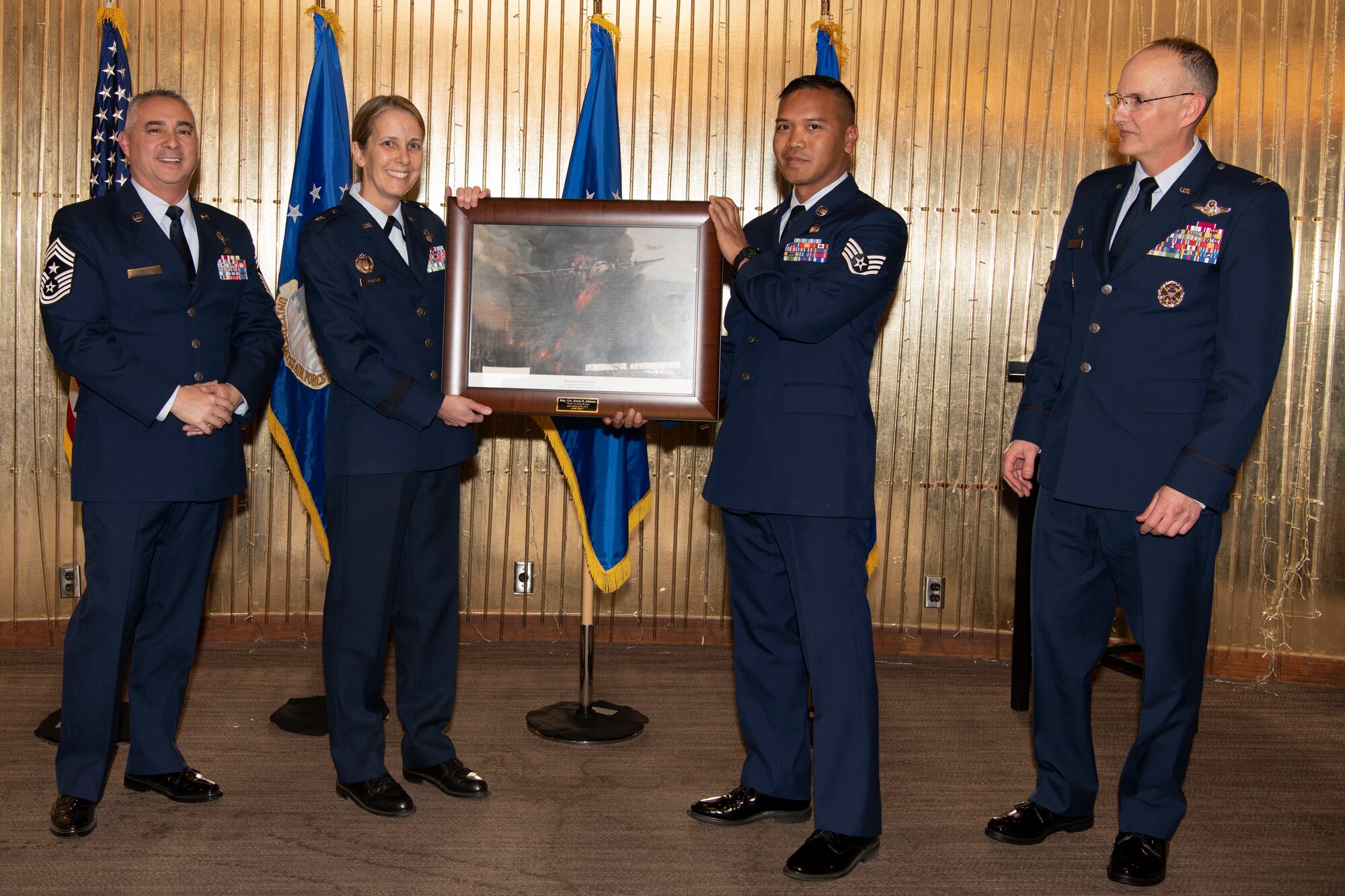 Brig. Gen. Jennie Johnson, Headquarters Air Reserve Personnel Center commander, receives a framed artist’s rendition of the 302nd Airlift Wing’s aerial firefighting mission during the 302AW Annual Awards Ceremony March 5, 2022, at Peterson Space Force Base, Colorado