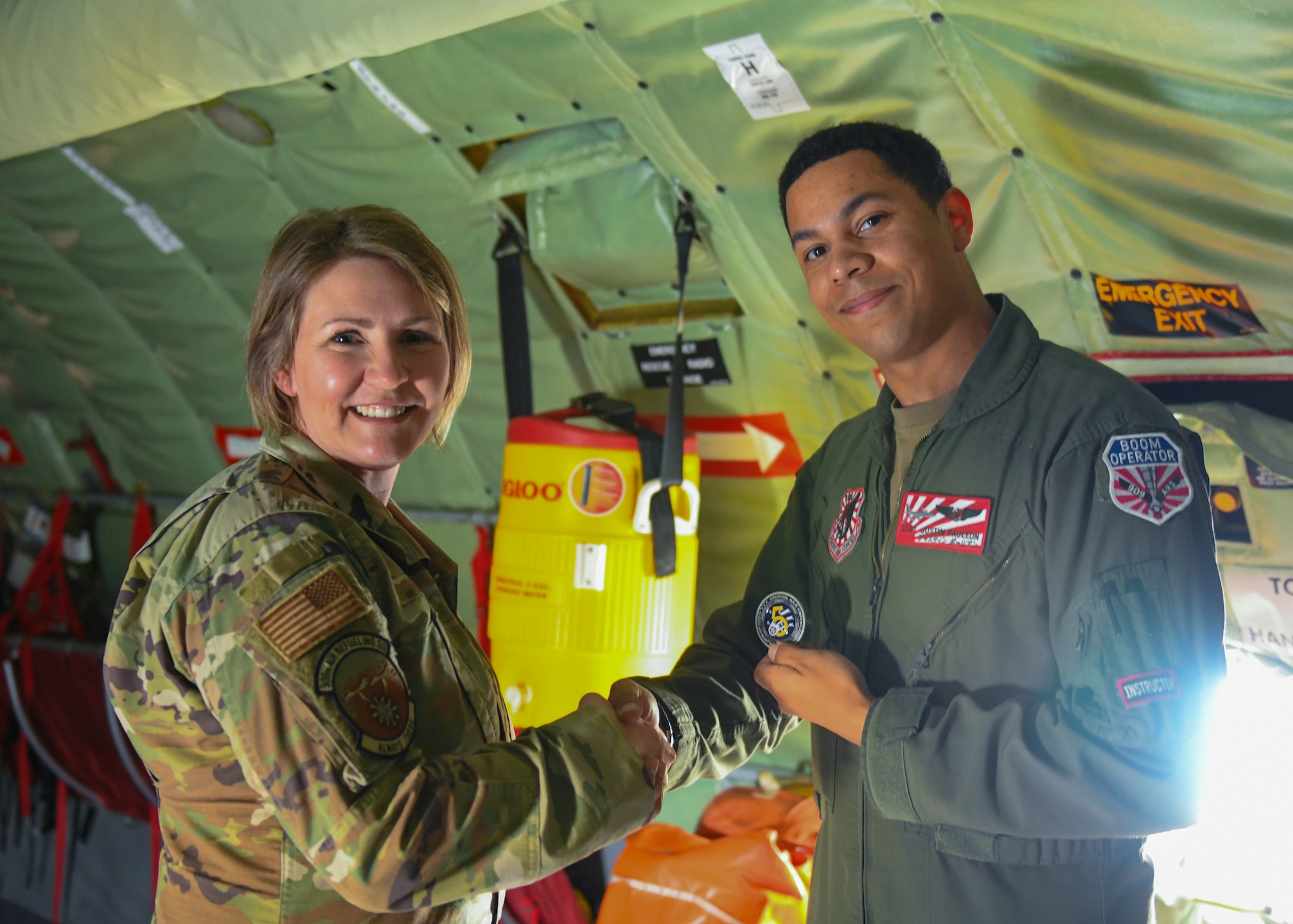 Photo of Chief Master Sgt. Katie McCool coining Staff Sgt. Justin Pauleon.