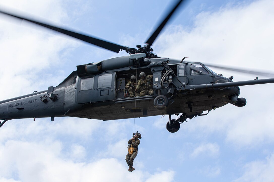 U.S. Marines and Navy corpsmen attending the Jungle Warfare Training Center’s Jungle Medicine and Communications Courses, and Airmen with 33rd Rescue Squadron conduct casualty hoist training drills with a HH-60G Pave Hawk, at Camp Gonsalves, Okinawa, Japan, Feb. 24, 2022. Service members gained first-hand experience utilizing the jungle penetrator tool, developing proficiency in safe jungle extraction techniques and procedures. (U.S. Marine Corps photo by Cpl. Diana Jimenez)