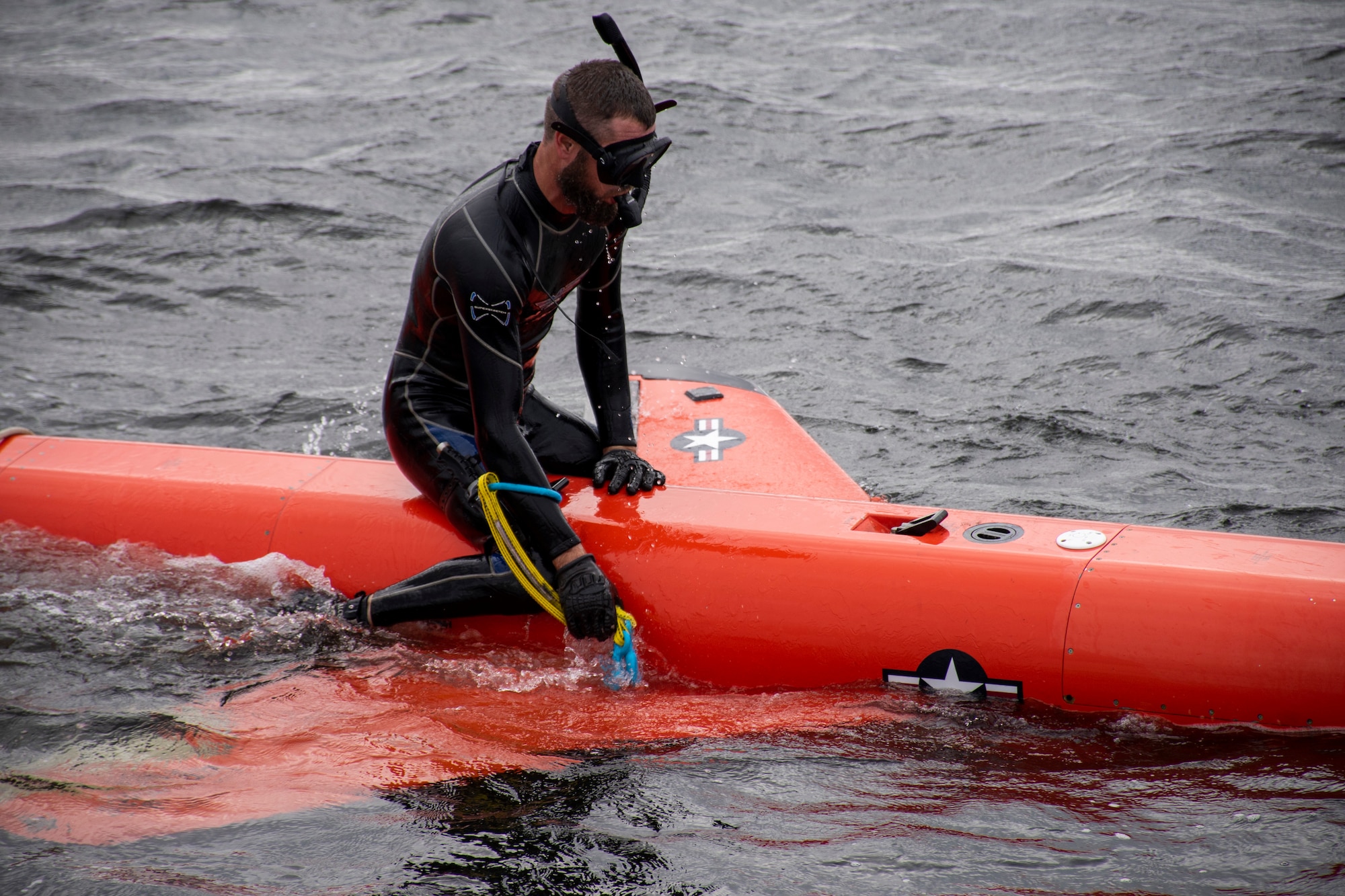 Morgan Baker, 82nd Aerial Targets Squadron contractor, connects a harness to a BQM-167 subscale drone during a recovery demonstration in the East Bay near Tyndall Air Force Base, Florida, Dec. 17, 2021. The 82nd ATRS assigned personnel provide all U.S. Air Force aerial target support for the Department of Defense and international partners in the Eglin-Gulf ranges. (U.S. Air Force photo by 1st Lt. Lindsey Heflin)