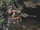 Green Berets with 1st Battalion, 1st Special Forces Group (Airborne) alongside their Marine counterpart move through a swamp during the 4th Marine Regiment Jungle Warfare Exercise at the Jungle Warfare Training Center, May 23, 2021. The exercise includes forward reconnaissance, terrain analysis, practice using a variety of communication platforms, small unit tactics and patient extraction procedures.