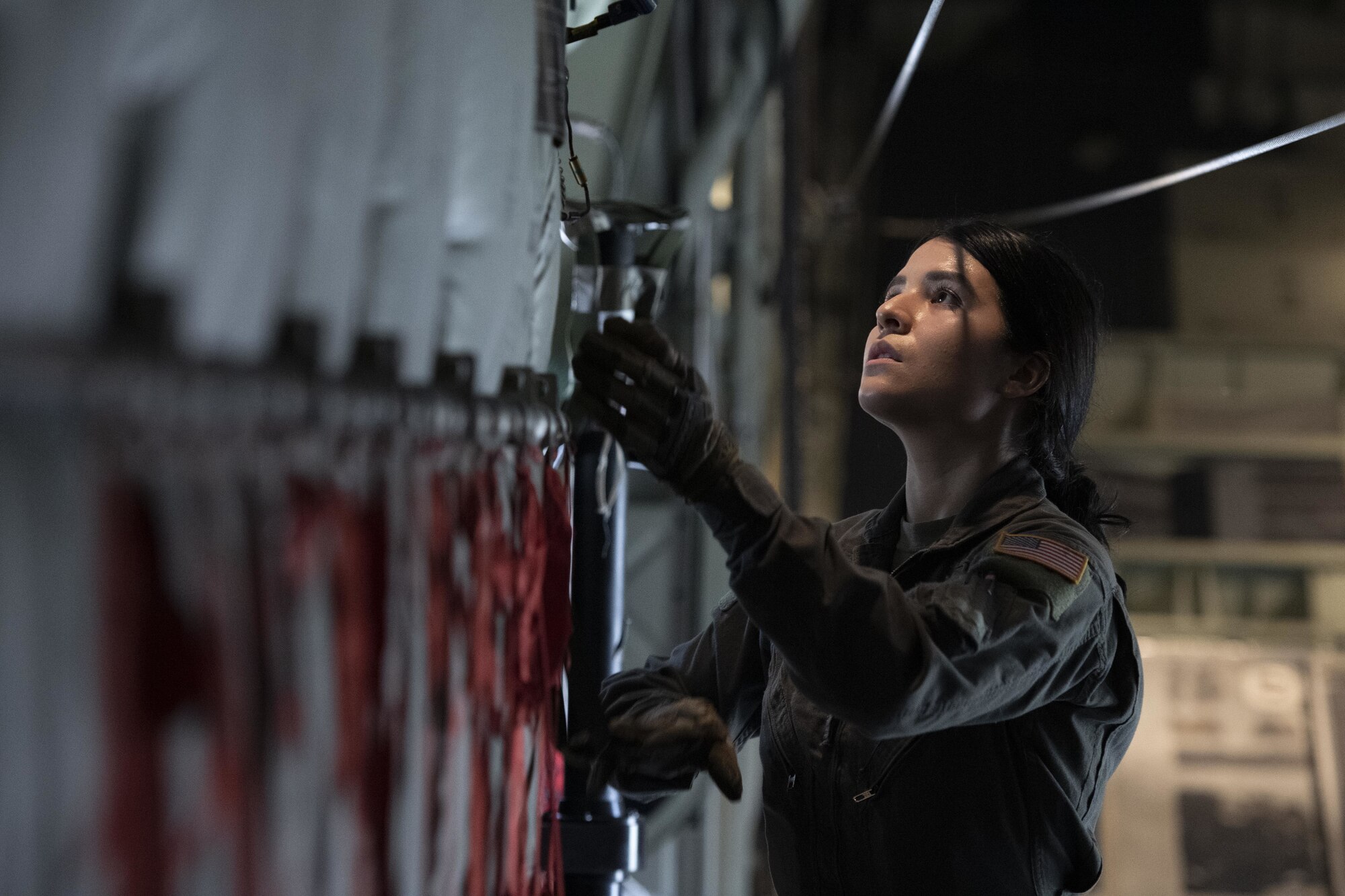 Senior Airman Kristen Garcia, 36th Expeditionary Airlift Squadron loadmaster, prepares cables for static line jumps during Exercise Cope South 2022, Feb. 22, 2022, at Bangladesh air force (BAF) Base Bangabandhu, Bangladesh. U.S. and Bangladesh air forces conducted static line and high altitude, low opening (HALO) jumps during the exercise. The bilateral exercise provides an opportunity for Pacific Air Forces and the BAF to strengthen their relationship and enhance interoperability, to operate more effectively together when needed.