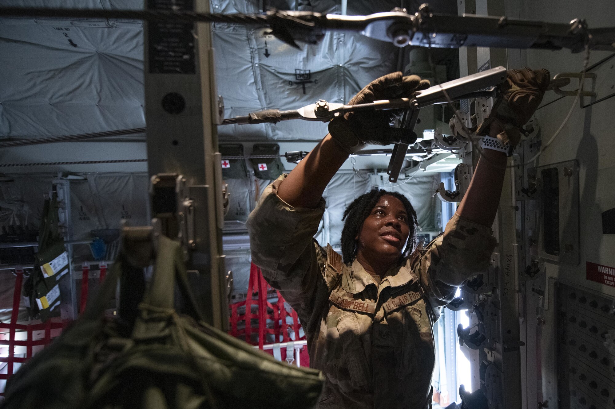Staff Sgt. Toiannah Campbell, 36th Expeditionary Airlift Squadron loadmaster, prepares cables for static line jumps during Exercise Cope South 2022, Feb. 22, 2022, at Bangladesh air force (BAF) Base Bangabandhu, Bangladesh. U.S. and Bangladesh air forces conducted static line and high altitude, low opening (HALO) jumps during the exercise. The bilateral exercise provides an opportunity for Pacific Air Forces and the BAF to strengthen their relationship and enhance interoperability, to operate more effectively together when needed.