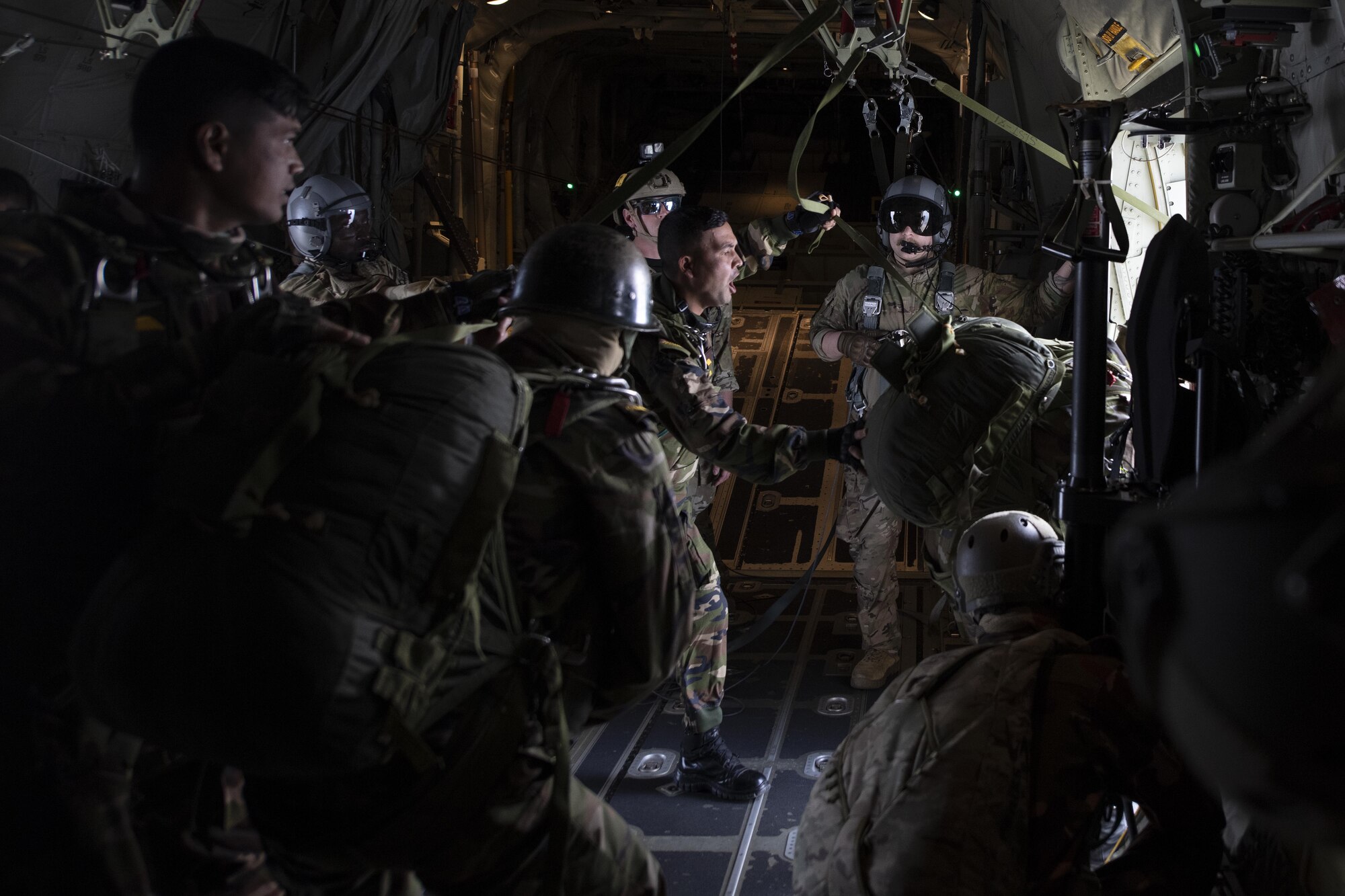 Tech Sgt. Wesley Zech, right, 36th Expeditionary Airlift Squadron loadmaster, observes as Bangladesh armed forces members jump from a C-130J Super Hercules during a static line jump as part of Exercise Cope South 2022, Feb. 22, 2022, over Bangladesh. U.S. and Bangladesh air forces (BAF) conducted static line and high altitude, low opening (HALO) jumps during the exercise. The bilateral exercise provides an opportunity for Pacific Air Forces and the BAF to strengthen their relationship and enhance interoperability, to operate more effectively together when needed.