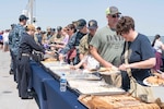 Sailors assigned to the Wasp-class amphibious assault ship USS Kearsarge (LHD 3) serve food during a Friends and Family Day event hosted aboard Kearsarge. The officers and crew of Kearsarge hosted a Friends and Family Day event to display their operational capabilities to their loved ones. (U.S. Navy Photo by MC3 Kaitlyn E. Eads/Released)