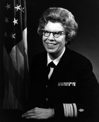 Official black and white portrait photo of woman in her uniform smiling toward off camera