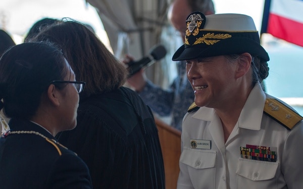 Woman in her white navy uniform talking to a sailor