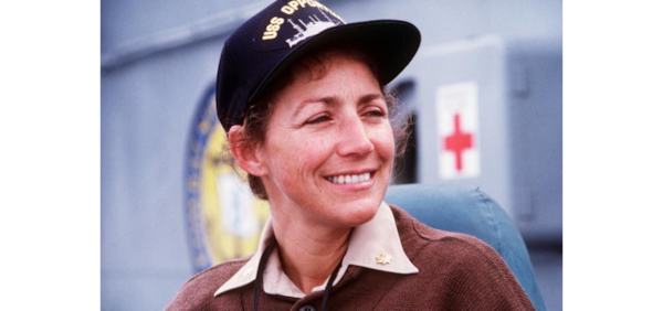 Smiling woman with navy cap looking away from the camera