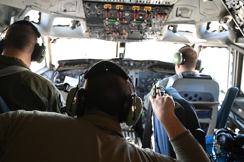 Three men on an aircraft flight deck