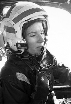 Black and white photo of woman in her pilot uniform in pilot seat
