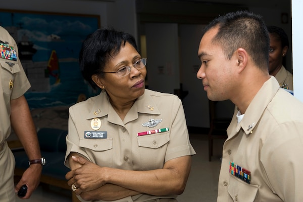 Woman in her beige navy uniform listening to sailor