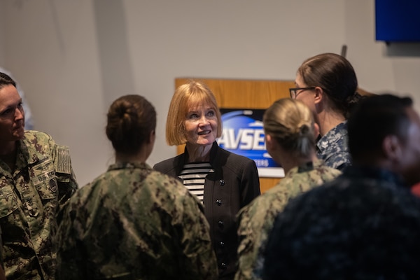 Rear Adm. Kathleen Paige, red hair woman in her civilian attire talking to sailors
