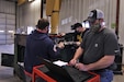 Brandon Johnson, a Department of the Army Civilian heavy mobile repair inspector with the Area Maintenance Support Activity-164, Lexington, Ky., right, reads a theory of operations of a 15-kilowatt Tactical Quiet Generator as Sgt. Justin Meidinger, assigned to the 452nd Ordnance Company, 451st Expeditionary Sustainment Command, Aberdeen, S.D., and a military technician with the AMSA- 108-Branch Maintenance Activity (BMA)-1 in Aberdeen, left, and fellow Soldier and co-worker Sgt. Larry Woodell, search for the relay during the Logistic Sustainment Training Power Generation class at the 88th Readiness Division-operated Fort McCoy, Wis., Draw Yard March 1, 2022.  The students learned about theory of operations for the first time since the class has been offered. (U.S. Army Reserve photo by Sgt. 1st Class Clinton Wood).