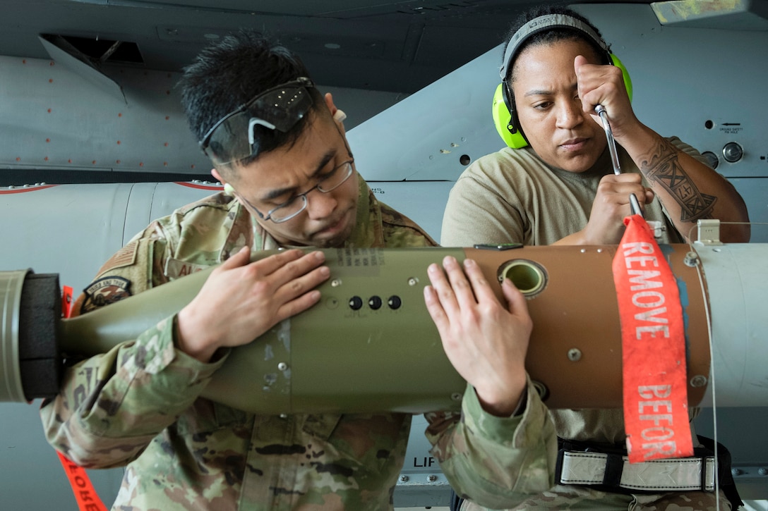 Airmen work on a simulated bomb during a competition.