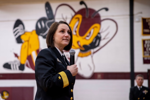 Woman in her uniform speaking at high school