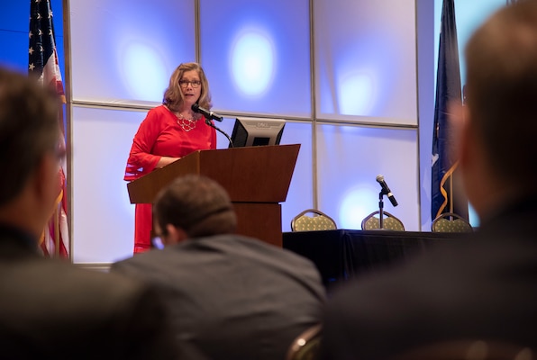 Woman in red dress/suit giving speech