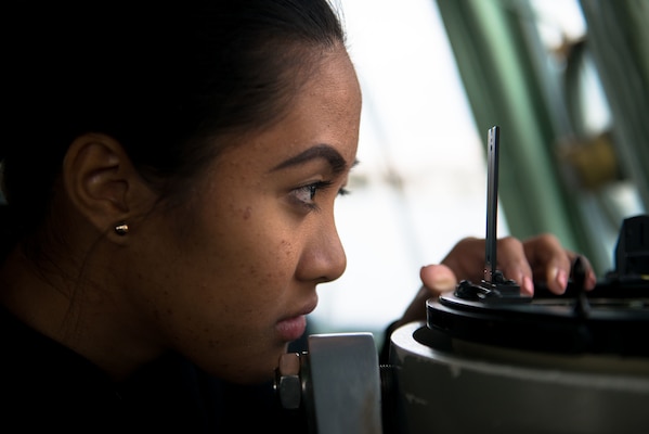 Woman looking at gyro compass during navigation course
