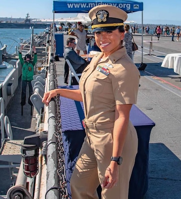 Women in her beige navy uniform smiling at camera on a pier