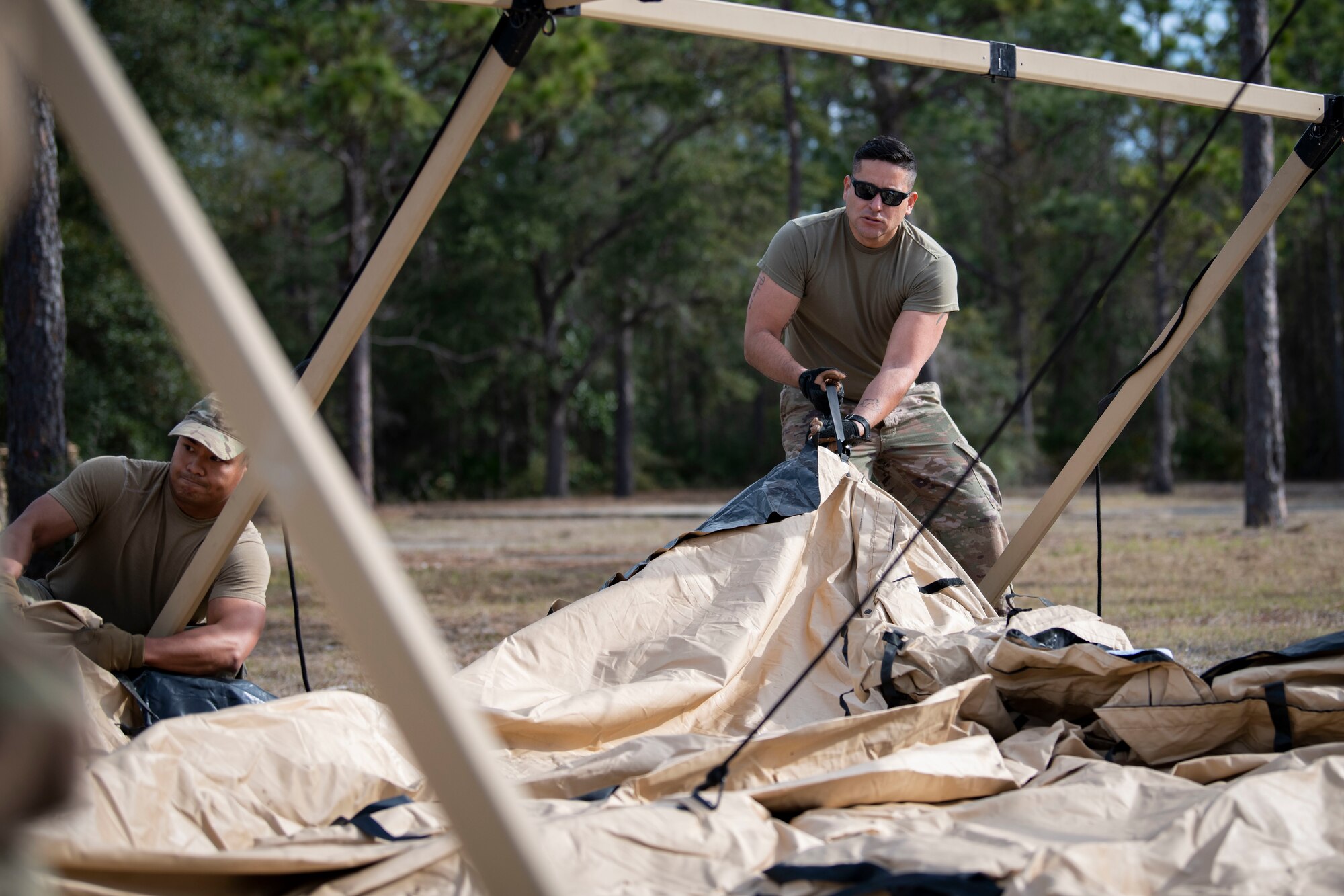 U.S. Air Force Senior Airman Diego CalleCalle, a 1st Special Operations Civil Engineer Squadron Mission Sustainment Team member, helps position the top of a military shelter system during a MST training March 3, 2022, at Hurlburt Field, Florida.