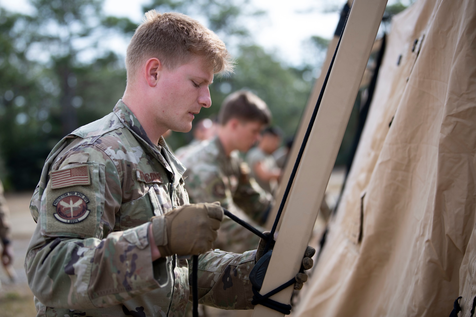 U.S. Air Force Airman 1st Class Andre Stencavage, a 1st Special Operations Security Forces Squadron Mission Sustainment Team member, helps build a military shelter system during a MST training March 3, 2022, at Hurlburt Field, Florida.
