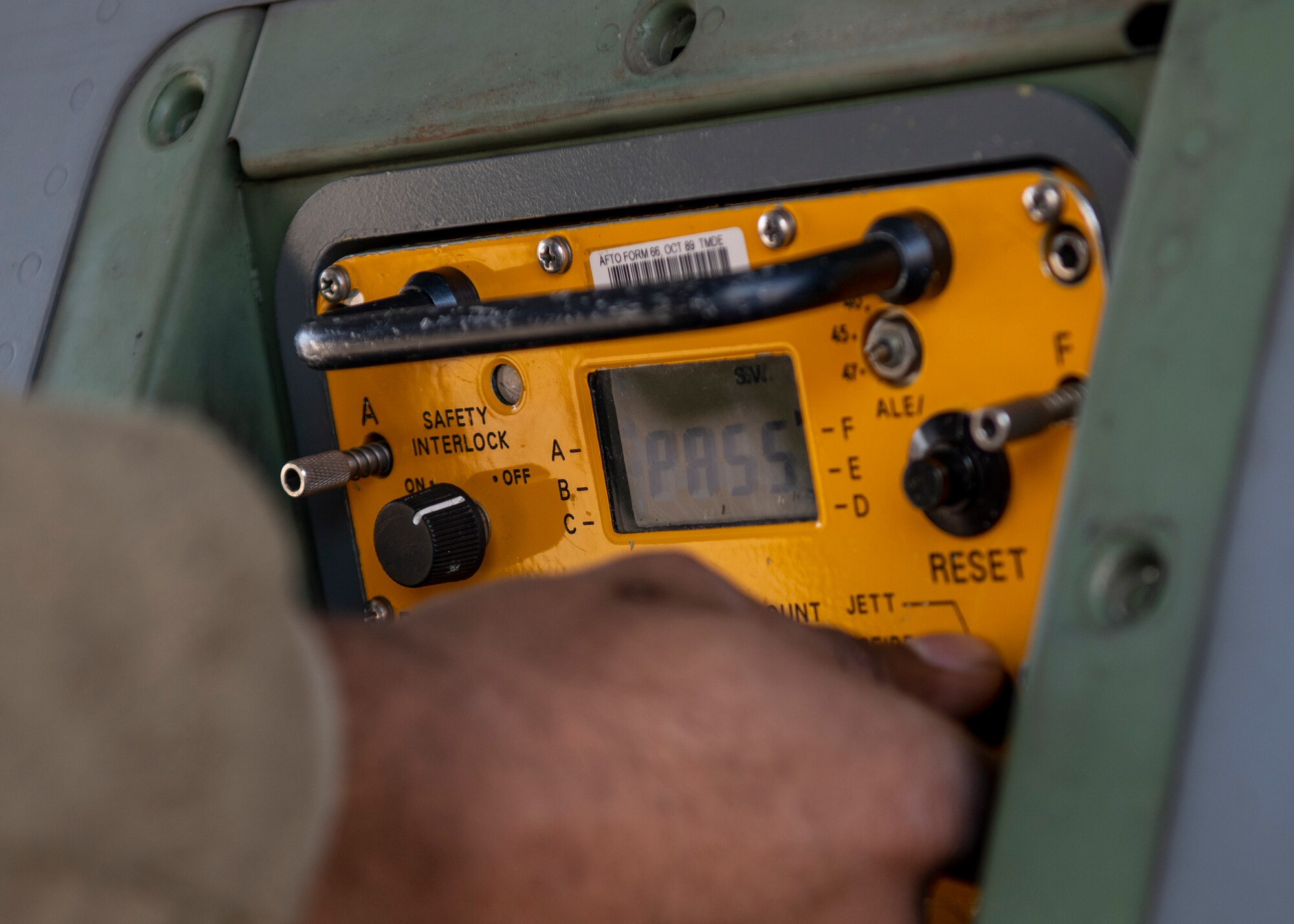 Closeup of a large voltmeter reading 'PASS' on its display.