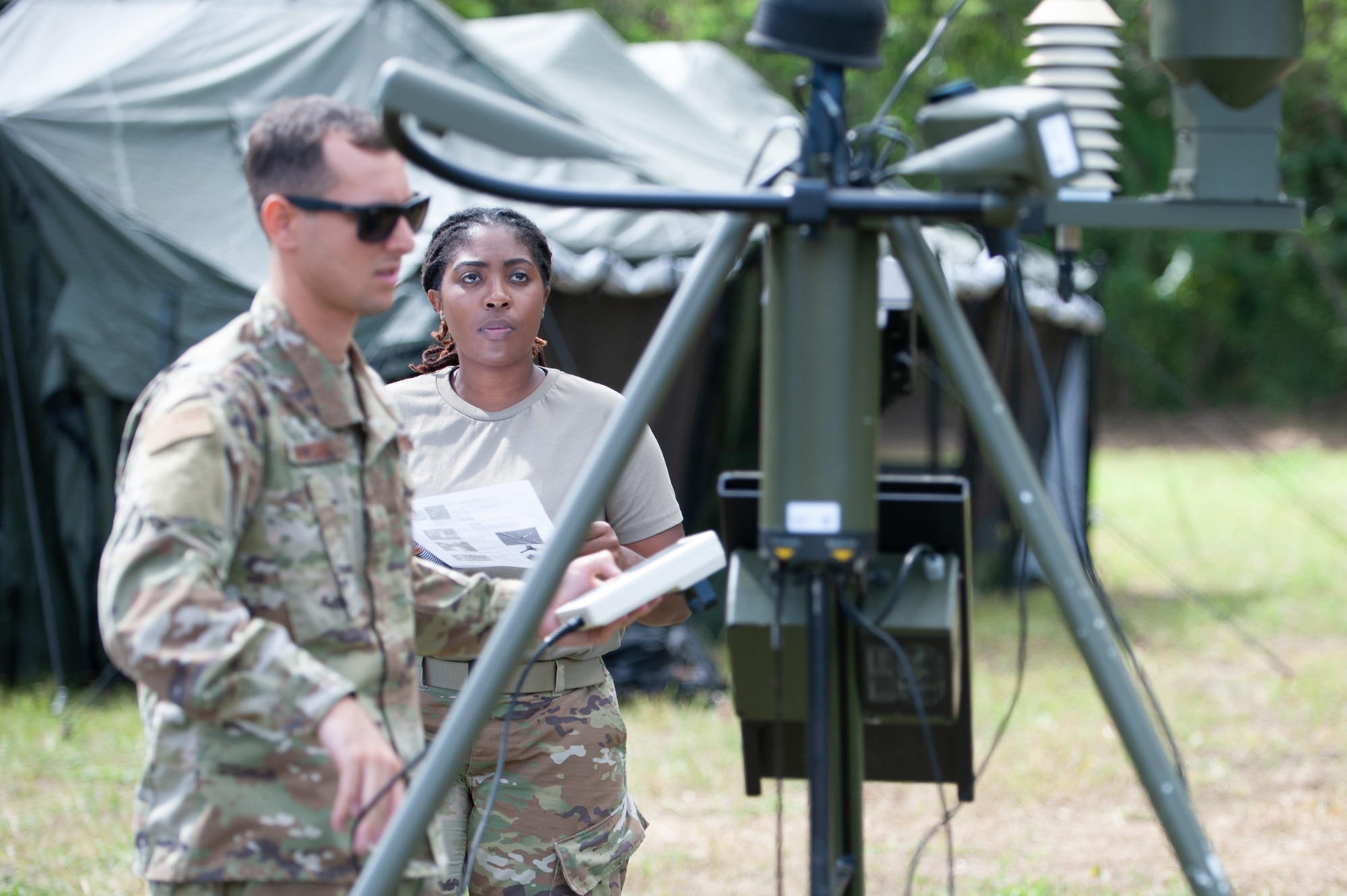 Senior Airmen Gabrielle Dequire and Adam Mattson with the 199th Weather Flight, Hawaii Air National Guard, set up a TMQ-53 Tactical Meteorological Observing System during aeromedical evacuation exercises at Dillingham Airfield March 4, 2022. The TMQ-53 is a portable, automated weather station that can take observations in up to one-minute intervals, enabling flying missions from anywhere in the world.