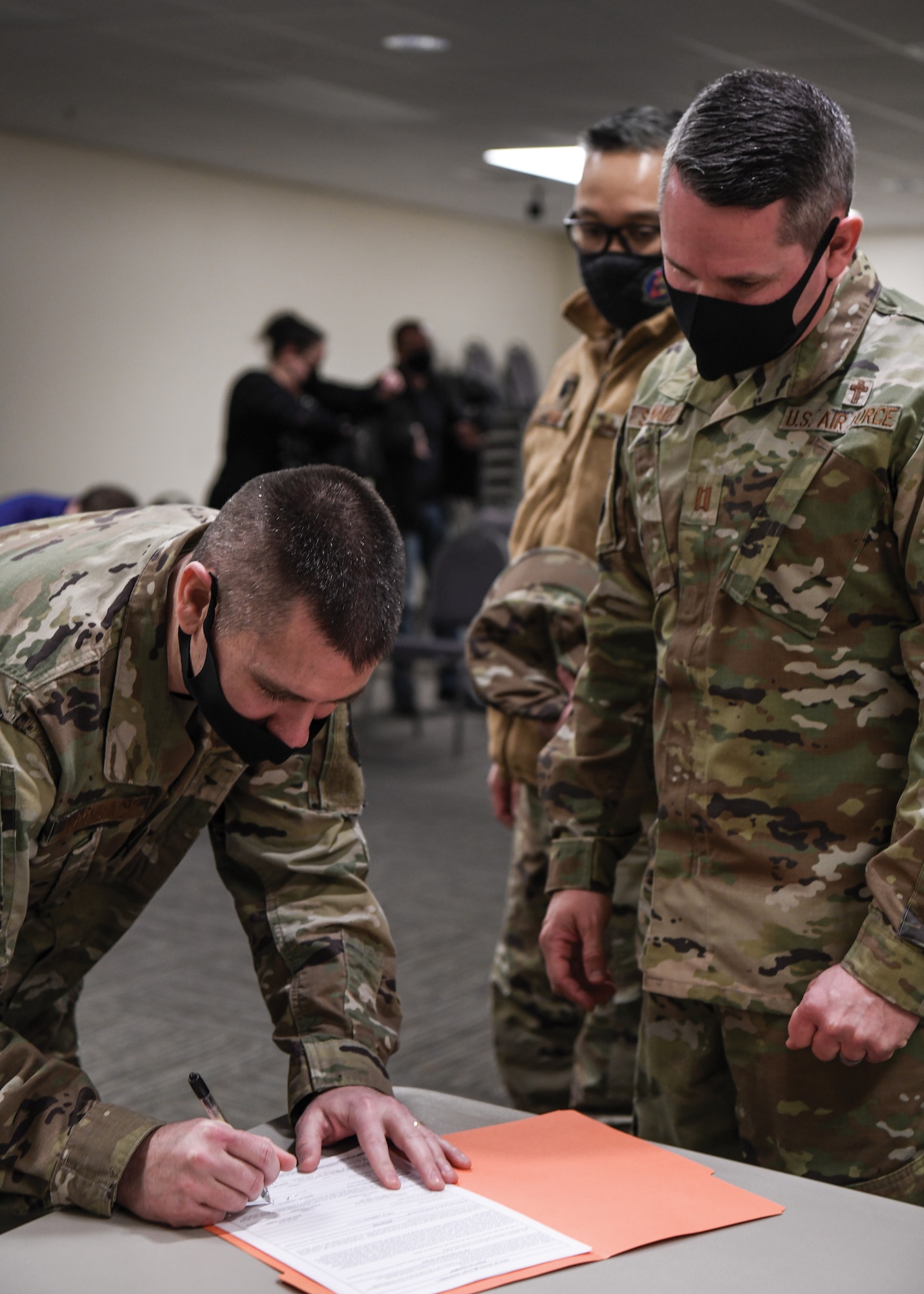 First Lt. Darrell Hornback signs Air Force Form 133, Oath of Office, with Chaplain (Capt.) Patrick Stalnaker. Hornback served as an enlisted Airman for 16 years before being commissioned into the Air Force Chaplain Corps Feb. 13, 2022.