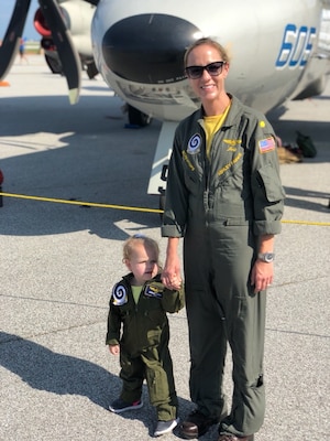 Woman in her uniform standing with her daughter who has same uniform