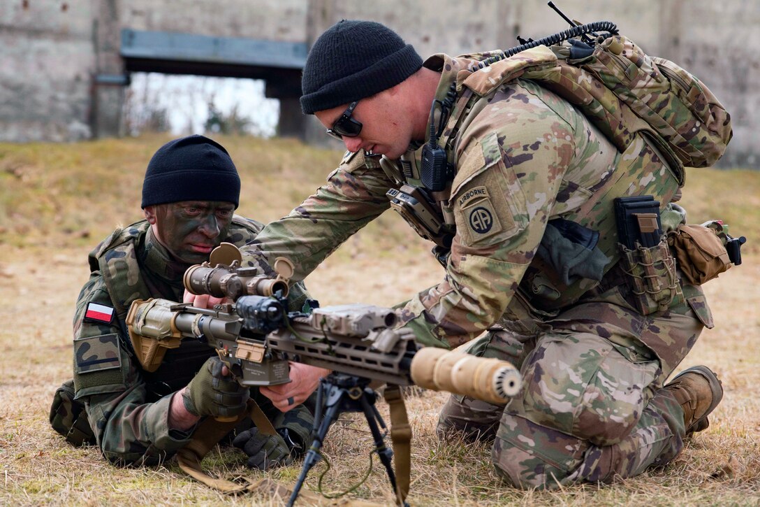 A soldier introduces a Polish soldier to an M110A1 squad designated marksman rifle during a training event.
