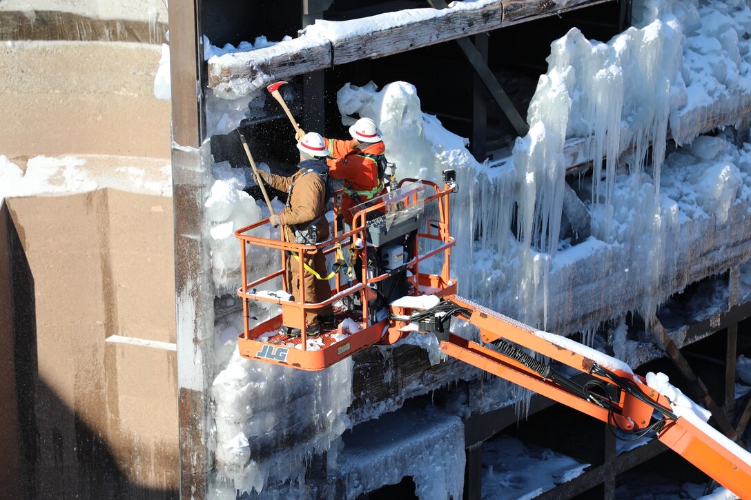 Winter maintenance crews at the Soo Locks in Sault Ste. Marie, Michigan work on chipping ice from the Poe Lock miter gate and using steam lines to melt the ice. This is needed so the gates can fully close.